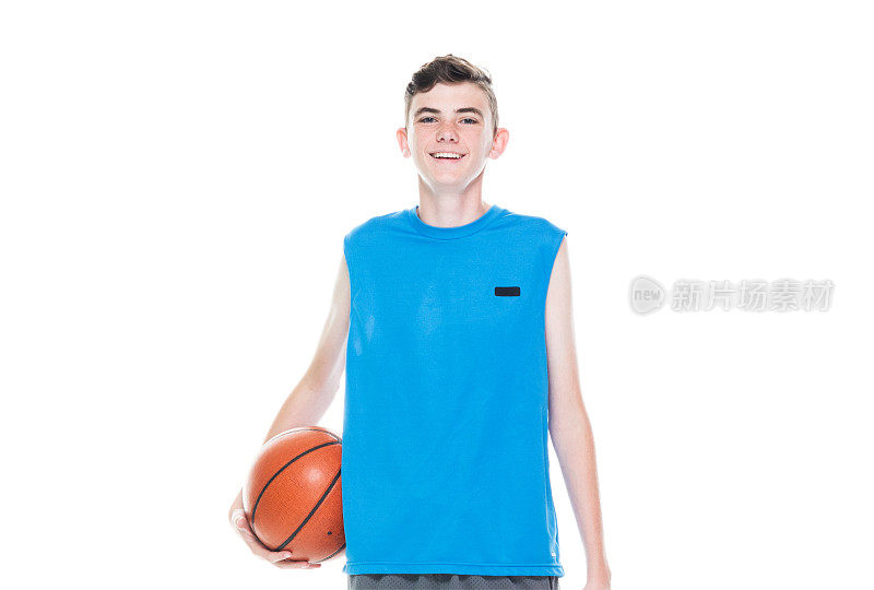 正面视图/一个人/一人/完整的长度/一个十几岁的男孩只有12-13岁英俊的人白人男性/年轻男子篮球运动员/男孩/十几岁的男孩站在白人背景和拿着篮球